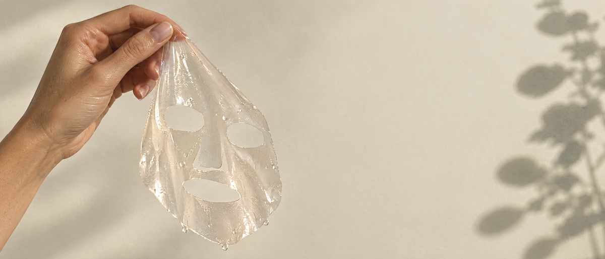 Hand holding a translucent hydrogel mask sheet